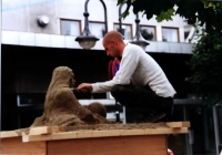 Stavanger: Ein Straßenkünstler moduliert eine Figur aus Sand